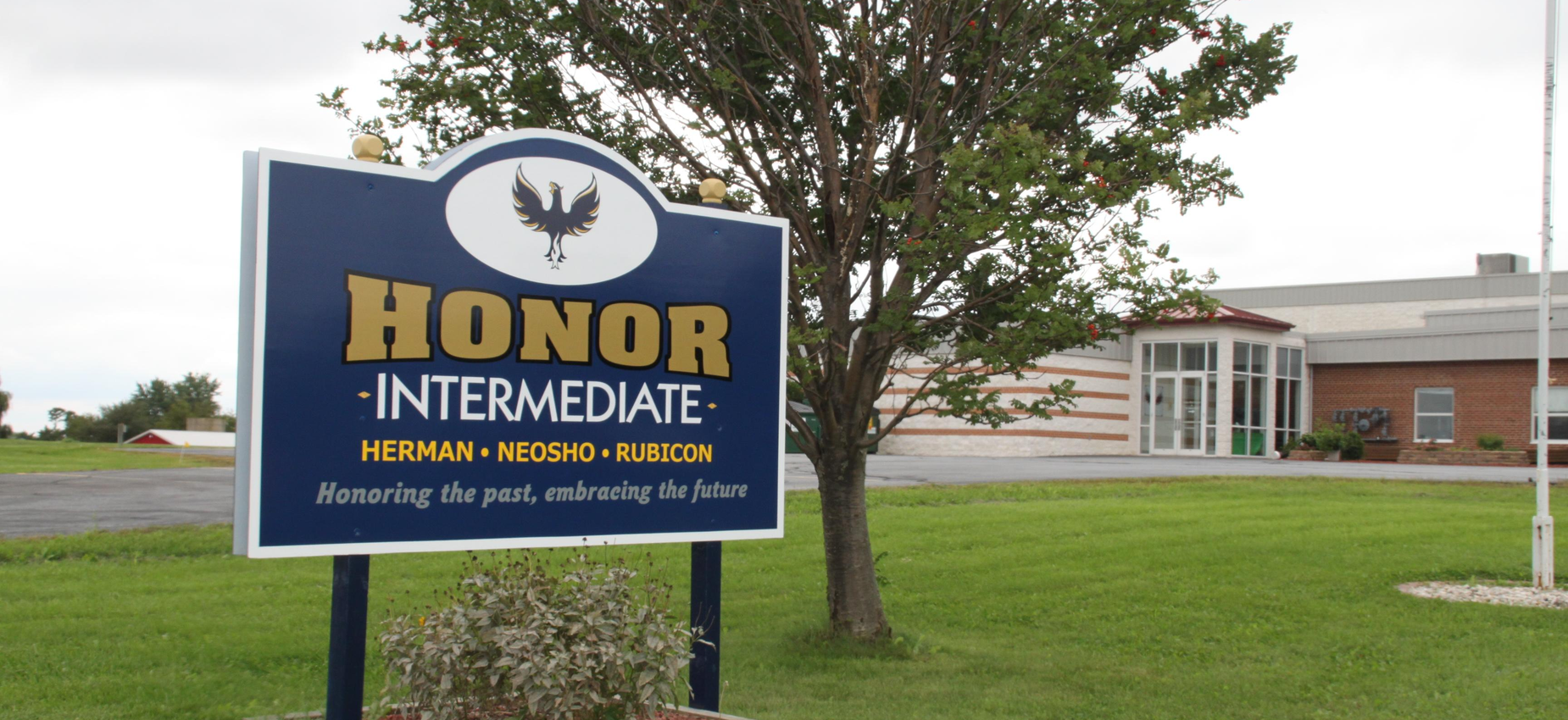 Sign for Honor Intermediate School with building in background.