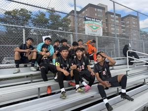 photo of boys soccer team sitting and posing