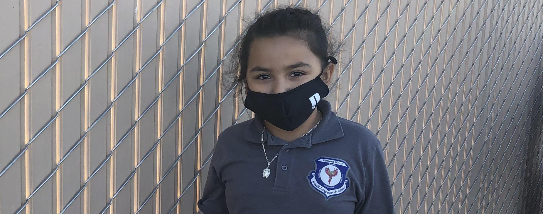 student with mask on in uniform polo