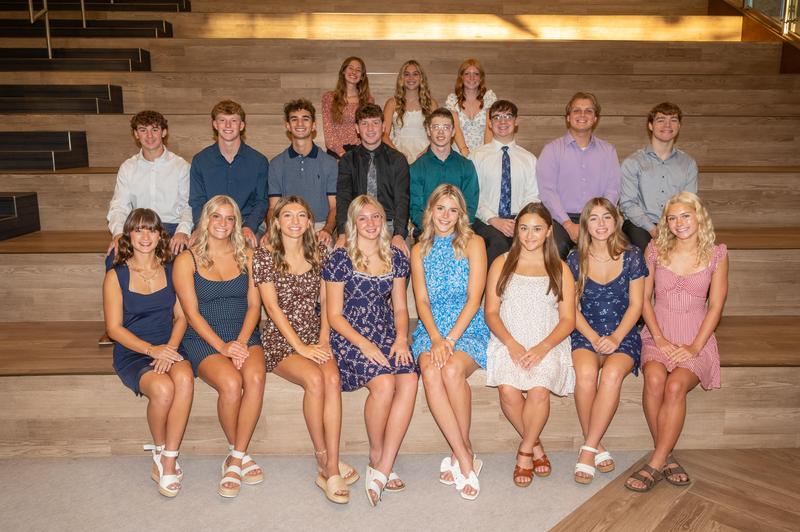 large group of students wearing dress clothes and sitting in a posed group