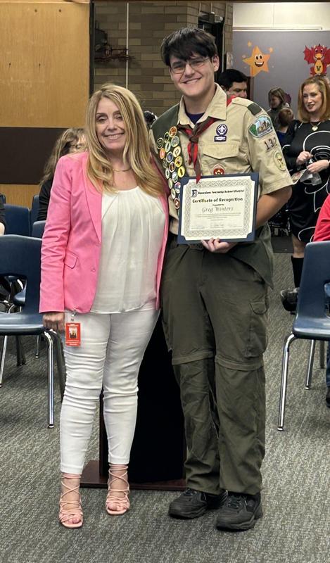Image of woman with Eagle Scout dressed in his uniform