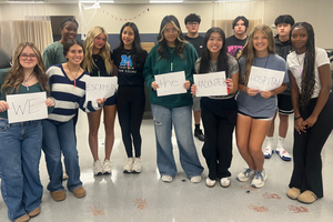 Memorial students pose with sign after escaping haunted escape room hospital