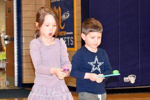 Two children focus on their spinning toys during a playful activity.