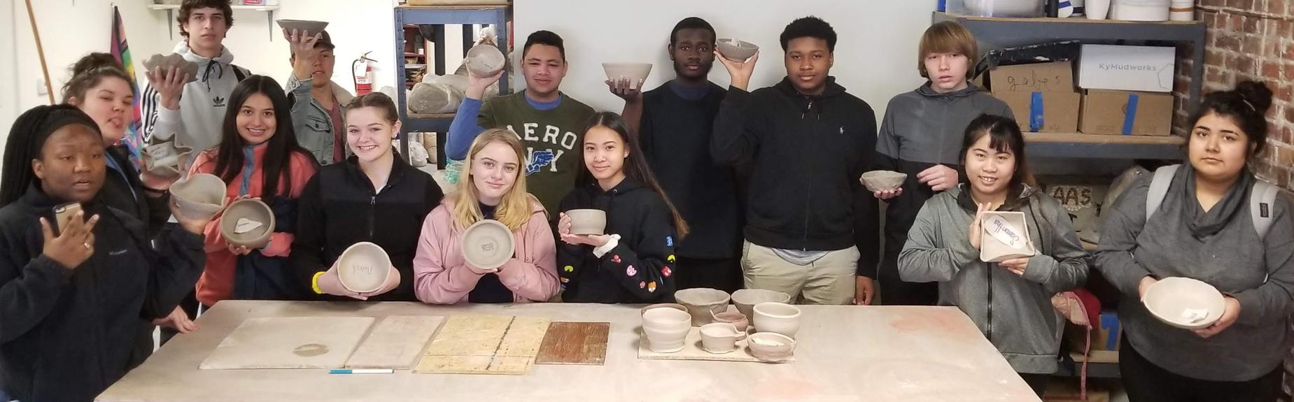 students holding up pottery they made at Pocosin Arts