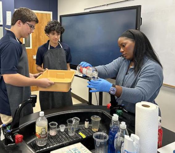 Biology teacher Crystal Stovall helps students with a class experiment.