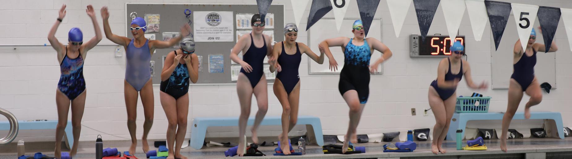 swimmers jumping into pool
