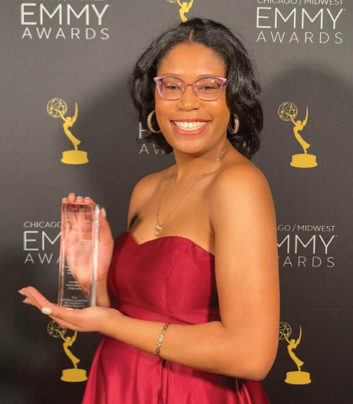 former student holding an award