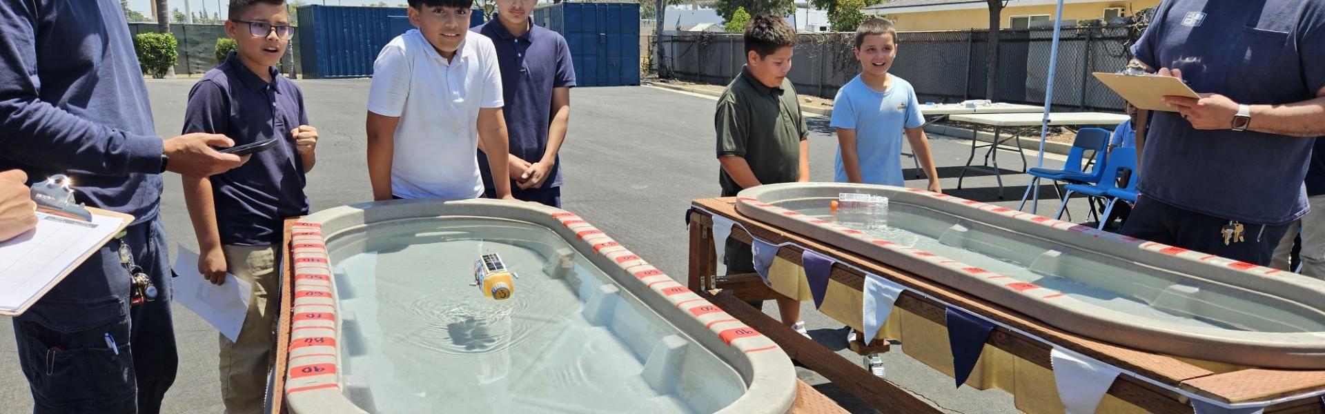 Students engaging in a water experiment with floating objects and measuring devices.