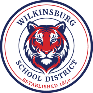A red and blue tiger face, inside a seal that reads Wilkinsburg School District, Established 1840
