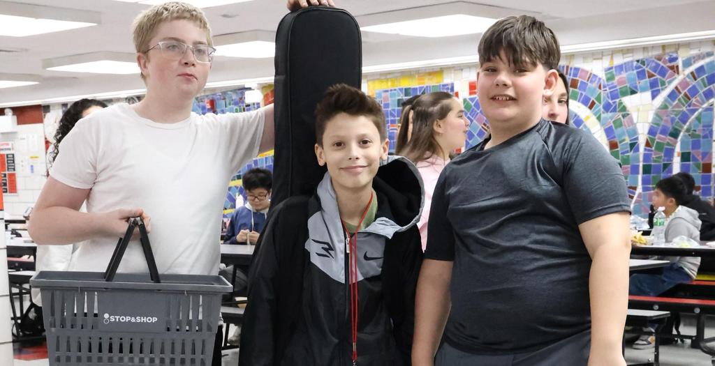 Three boys standing in the cafeteria.