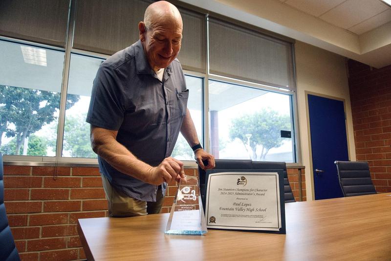Photo of Principal Paul Lopez in his office with his Champion of Character award