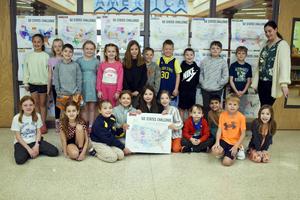 Another group of students standing with a similar map for the 50 states challenge behind them.