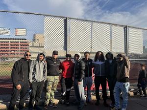 students outside by the field posing for a photo