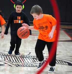 A student dribbles the ball up the court.