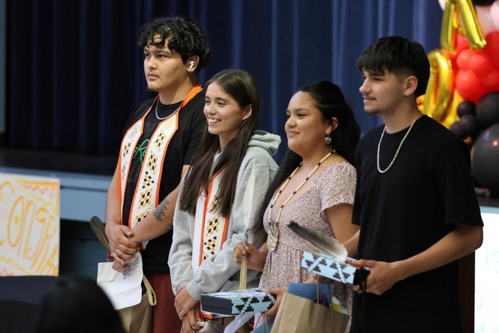 four students of Northern Pomo language with Eagle Feathers