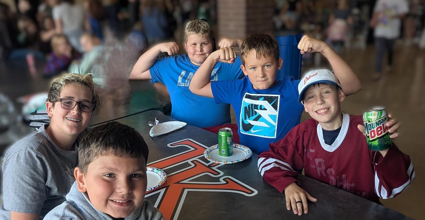 Five middle school boys enjoy pizza and pop after school.