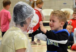 a student tossing a pie into a teacher's face