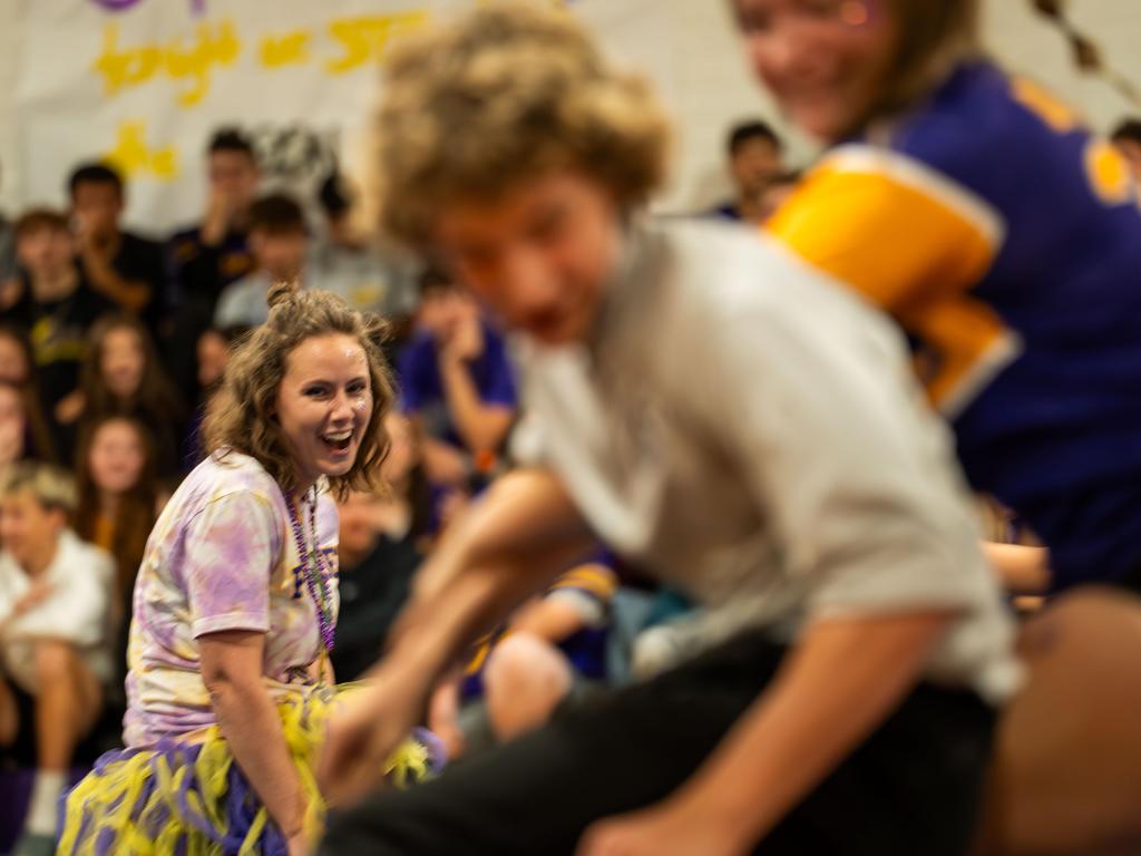 Woman laughing during a musical chairs game at a pep rally.