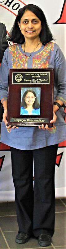 A photo of Supriya Khirwadkar, the Support Staff Member of the Year. She is holding a plaque with her photo on it.