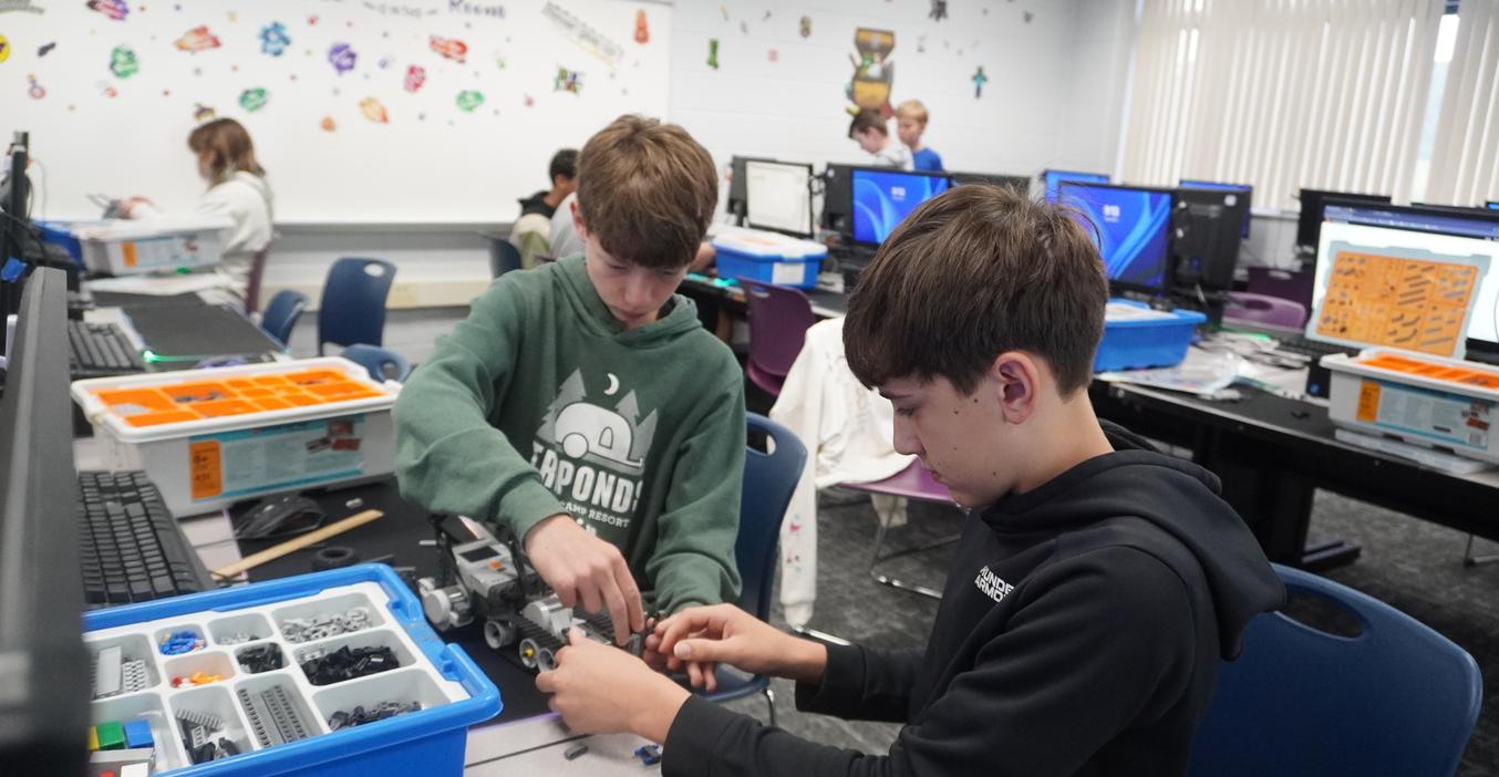 Two students work together to build their robot.