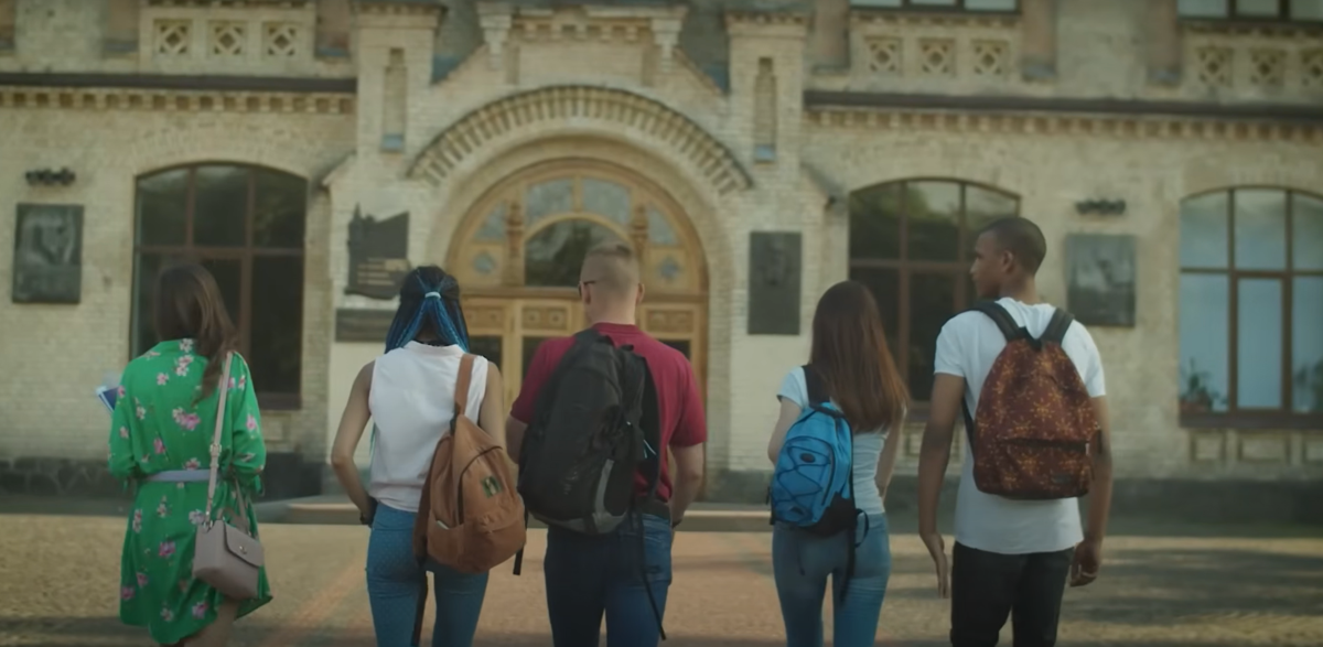 Students in from of a school walking towards the front door