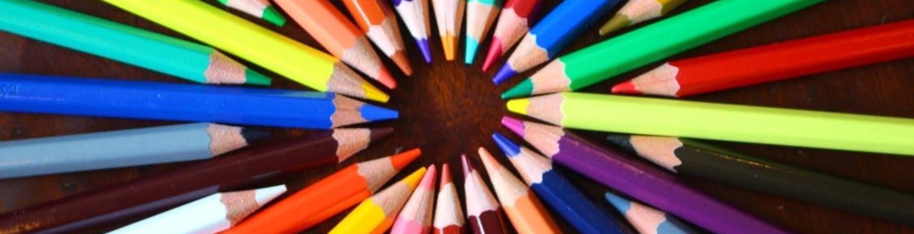 Colorful crayons arranged in a circular pattern on a wooden surface.
