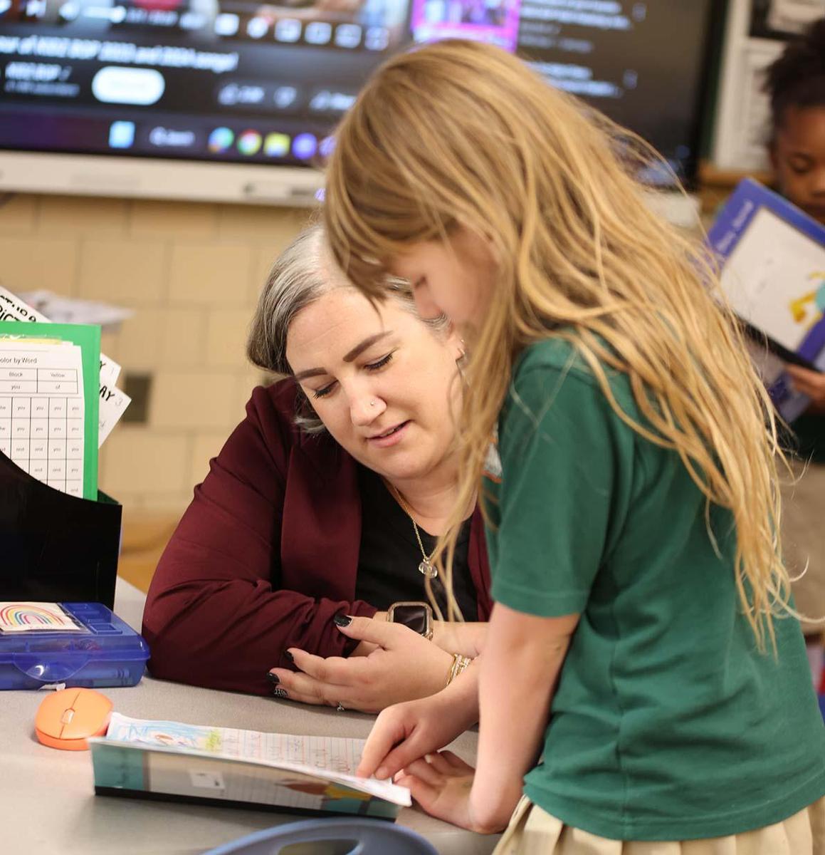 Student and teacher working together in a classroom.