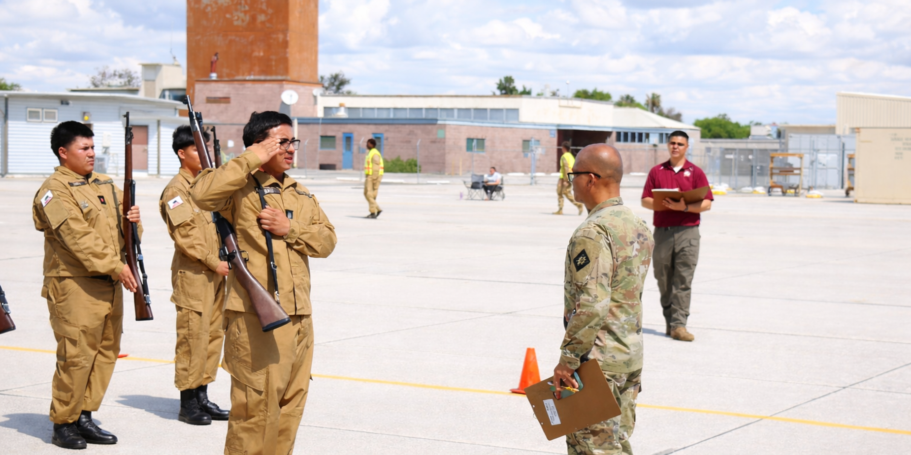 Soldiers in uniform salute an officer during a military ceremony outdoors.