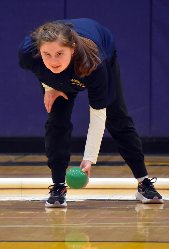 a girl rolling a bocce ball