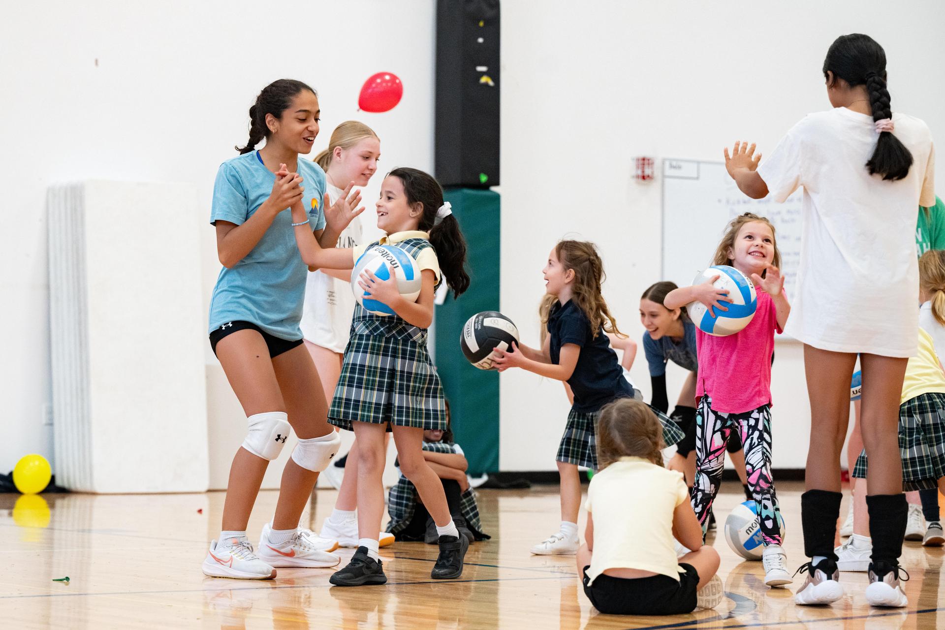 Girls Volleyball Team Practices Bumping with Campers