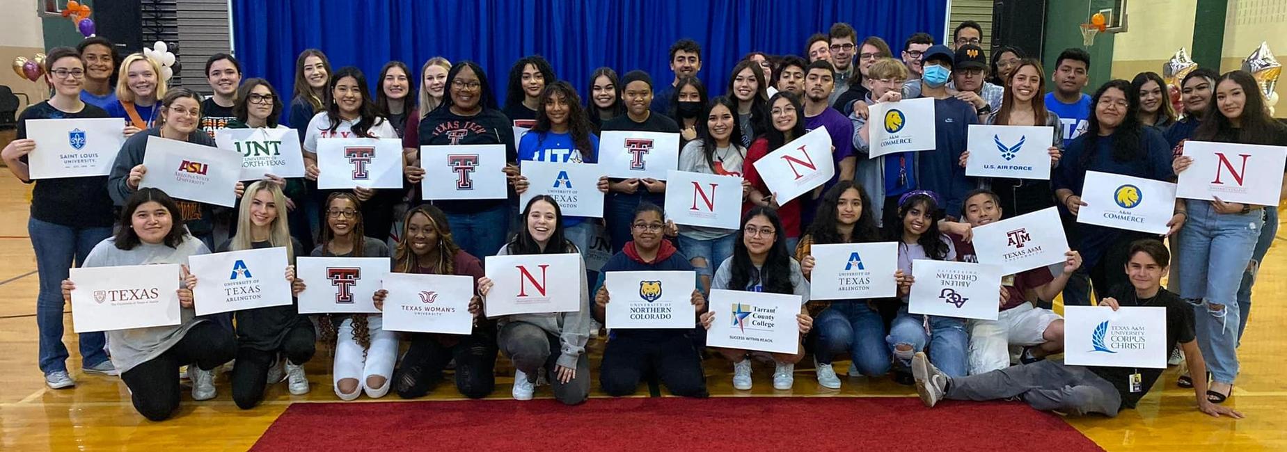 large group of high school seniors at college signing day ceremony