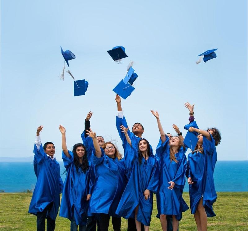 High school diploma recipients throwing caps in the air.
