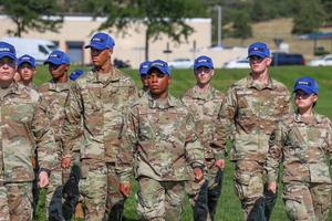 U.S. Air Force cadets in camouflage uniforms and blue hats.