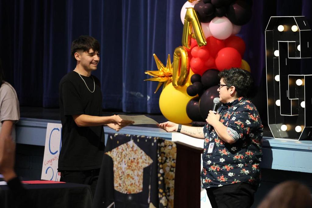 Principal Alvarez hands diploma to UHS graduate