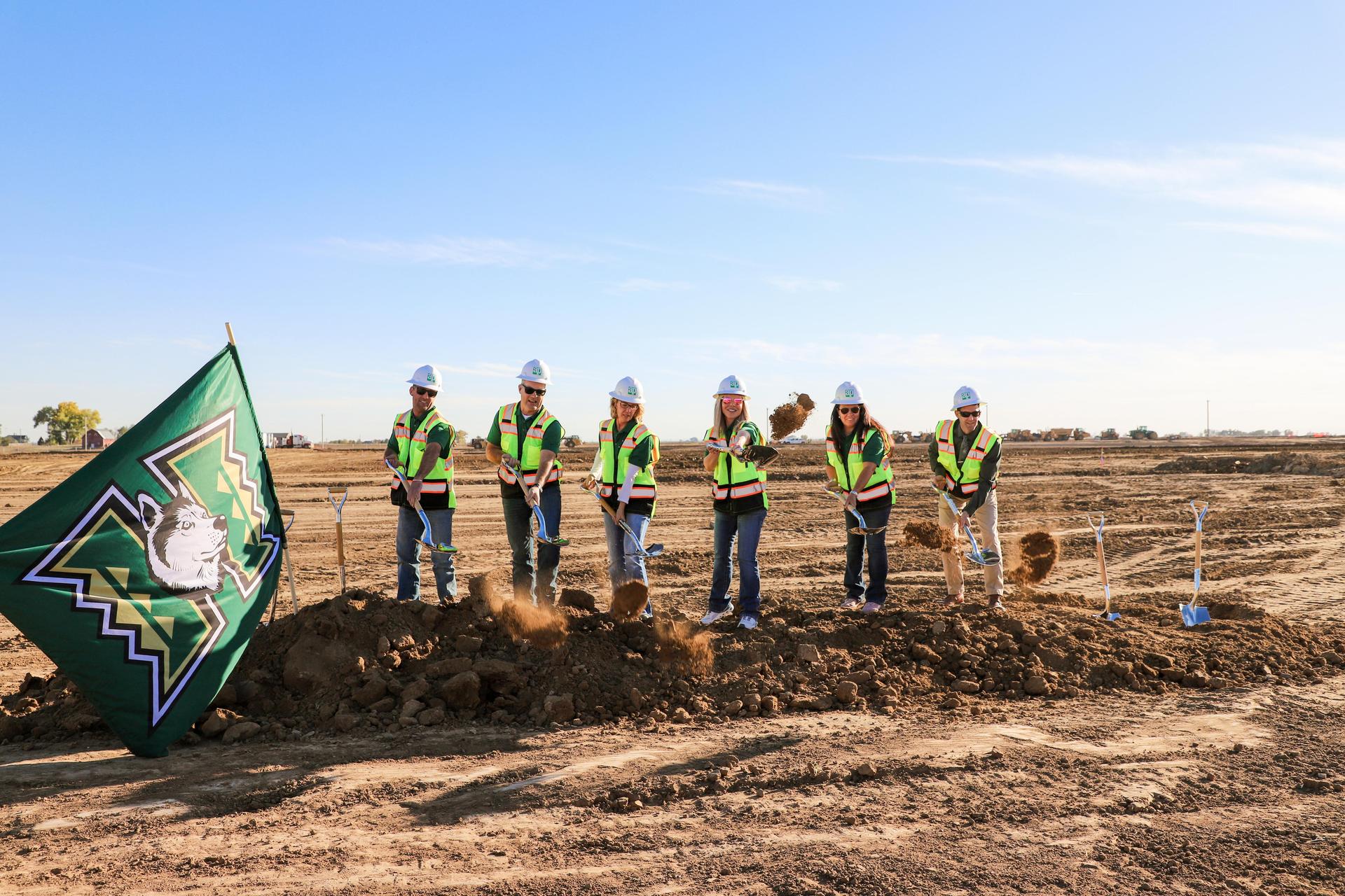 Group of board memebers with shovels at a groundbreaking ceremony.