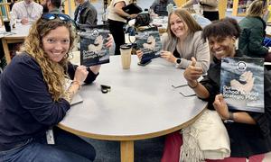Group of people sit around a table and show Strategic Plan
