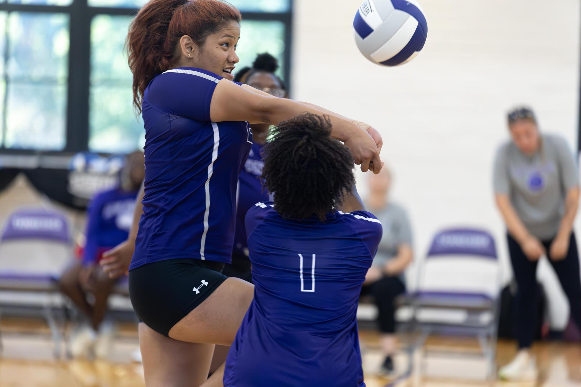 Player setting up for a volleyball spike while a teammate prepares to receive.