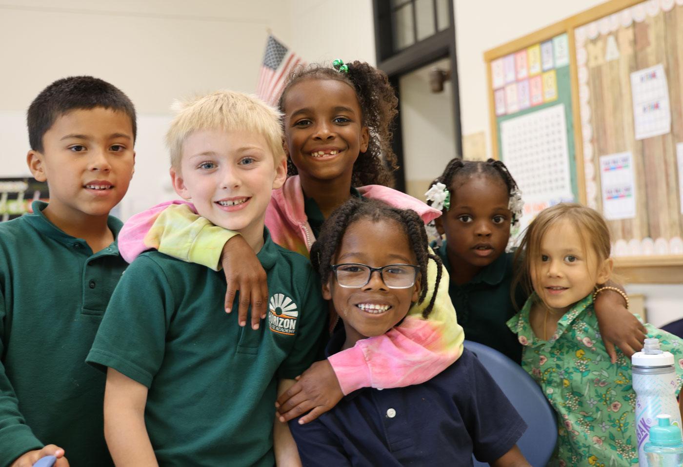 Group of students smiling and posing together in a classroom