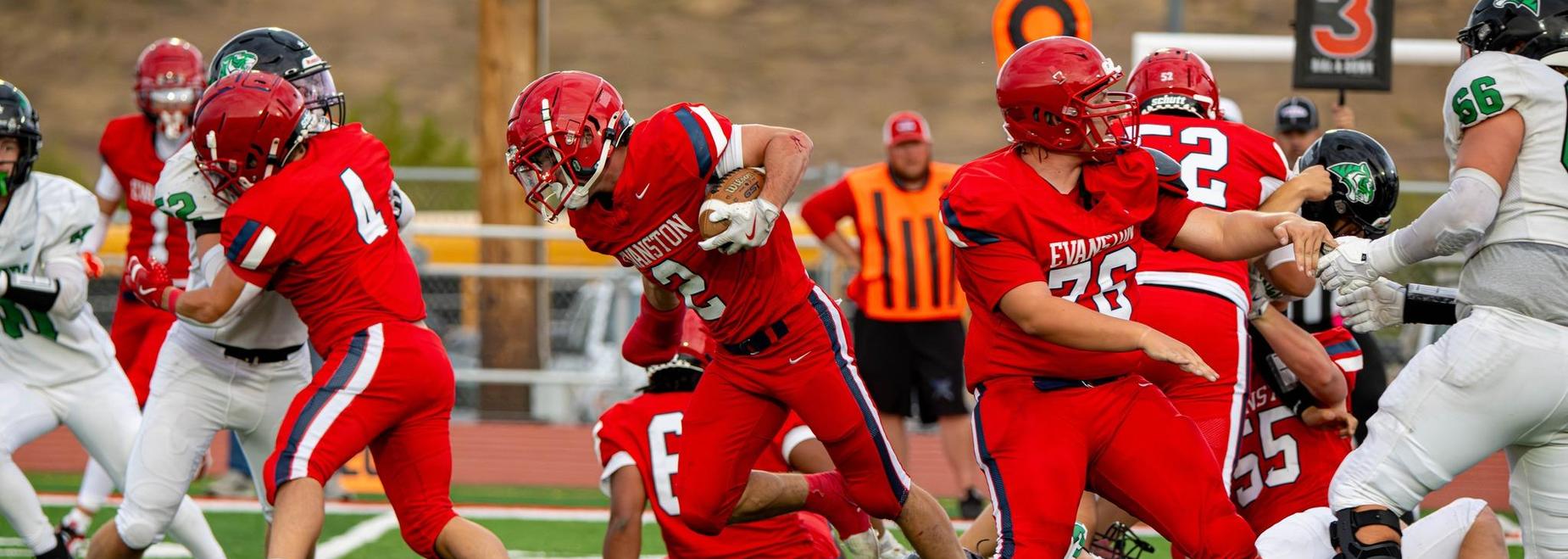 Football players engaged in a tackle during a game.