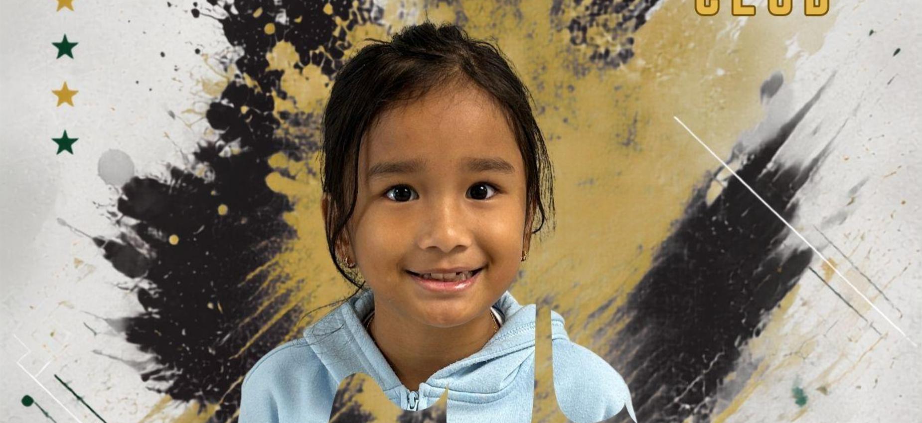 A smiling child with a blue hoodie on a colorful splattered background.