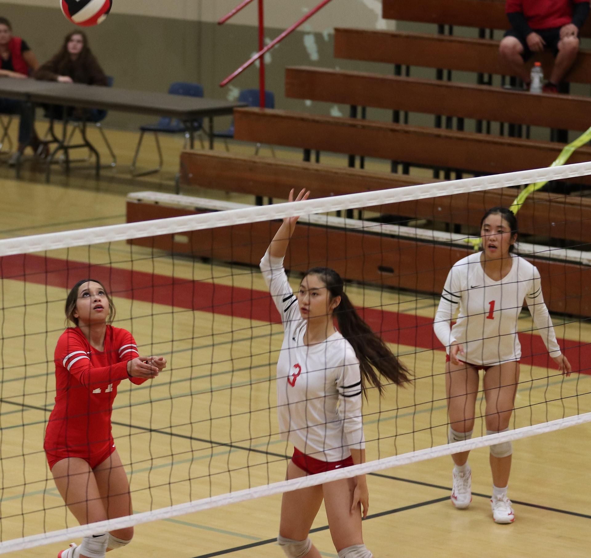 varsity volleyball players in action against Fresno Christian