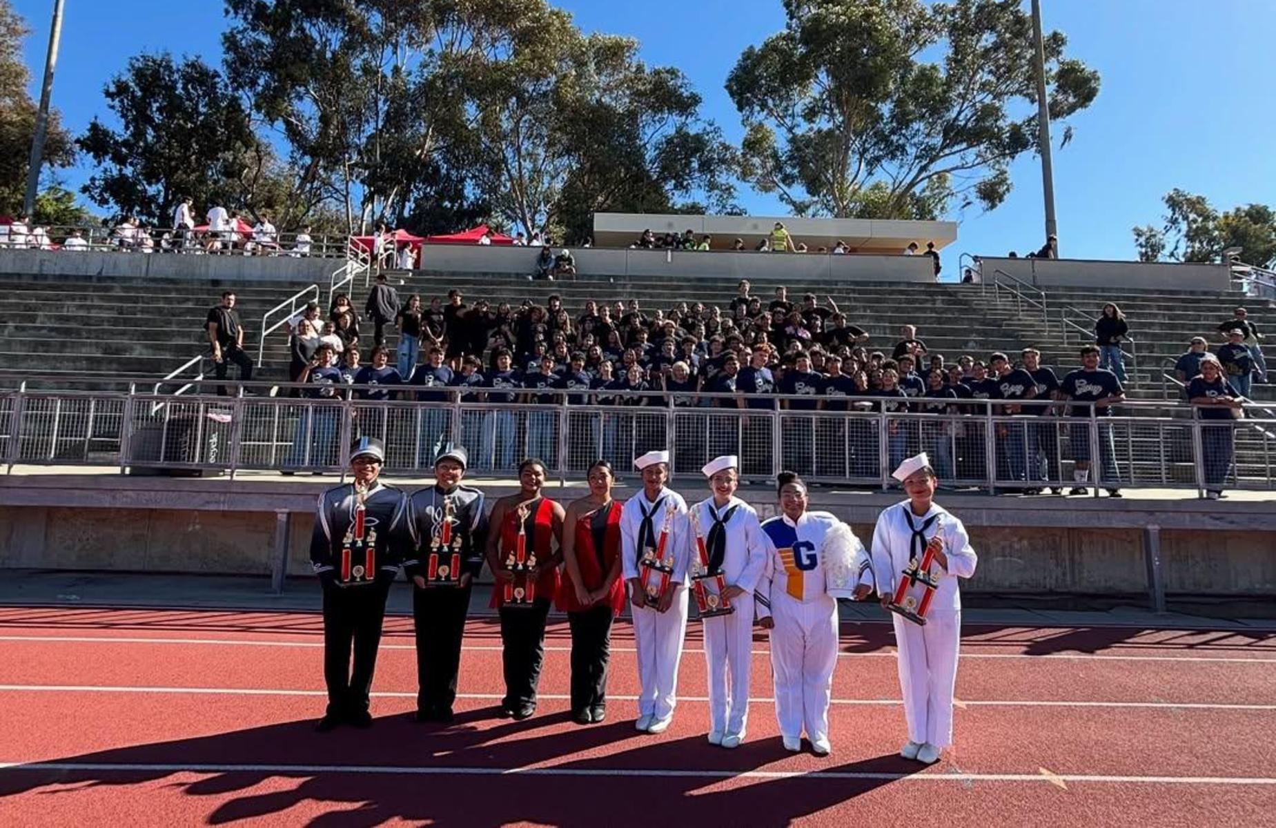 about 8 students and about 40 band members in the background
