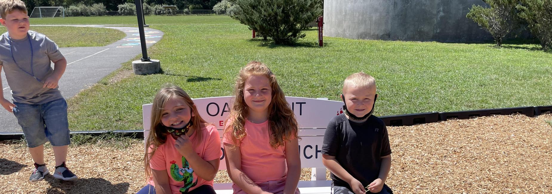 photo of students sitting on the Buddy Bench
