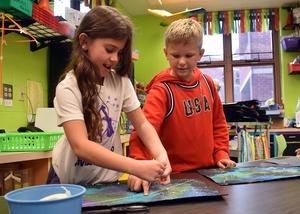 two girls tying a piece of string