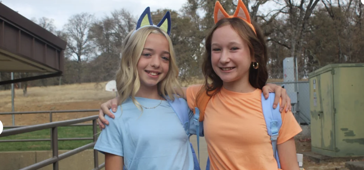 Bluey costumed students pose for a photo