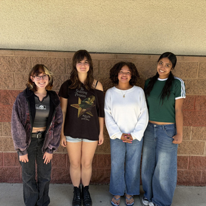 Four Valencia High School students pose outside the school building.