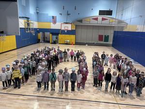 kindergarten students making 100 with bodies on gym floor
