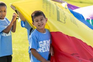 student playing with rainbow parachute game