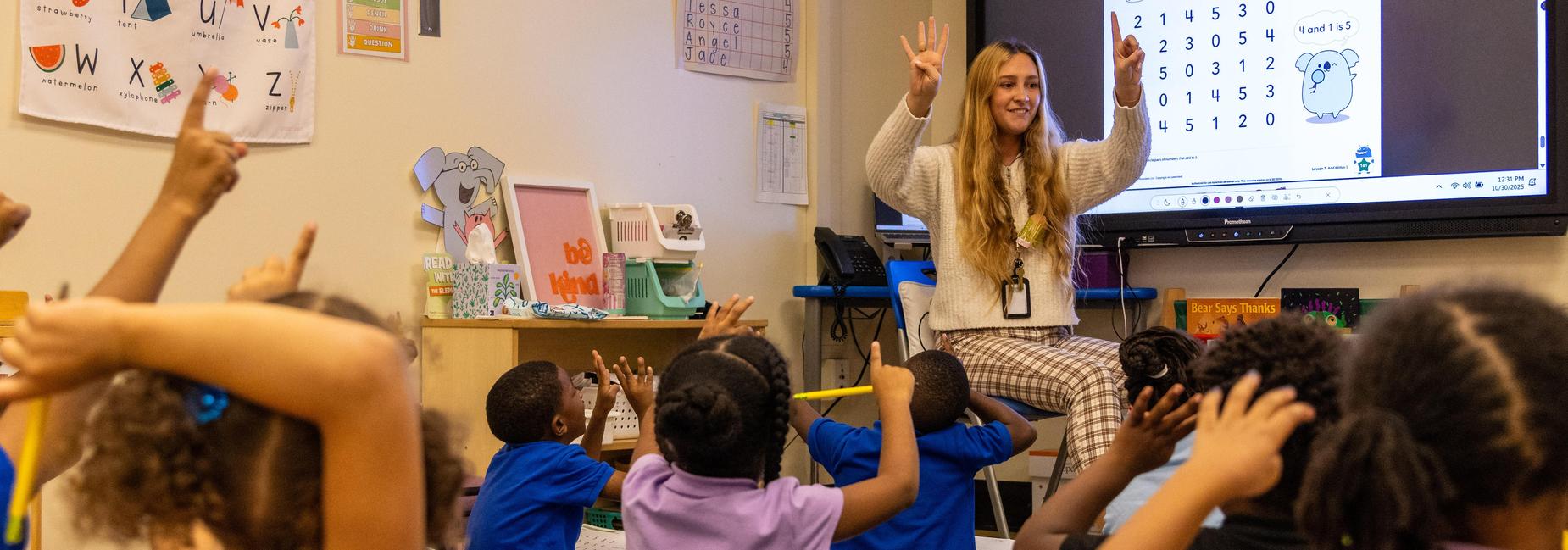A kindergarten teacher counts with her students