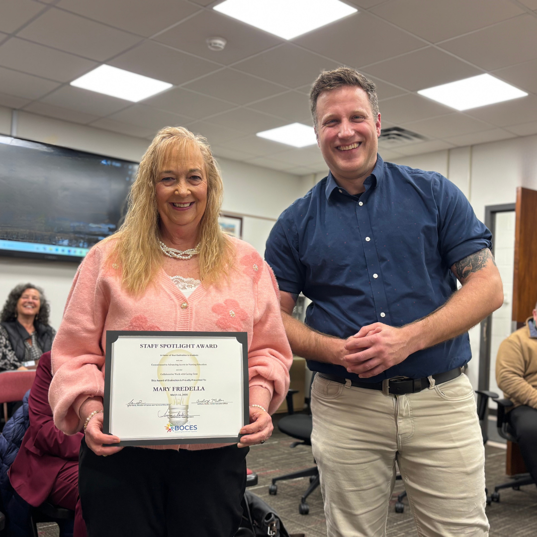 Mary Fredella holding a certificate standing next to a man